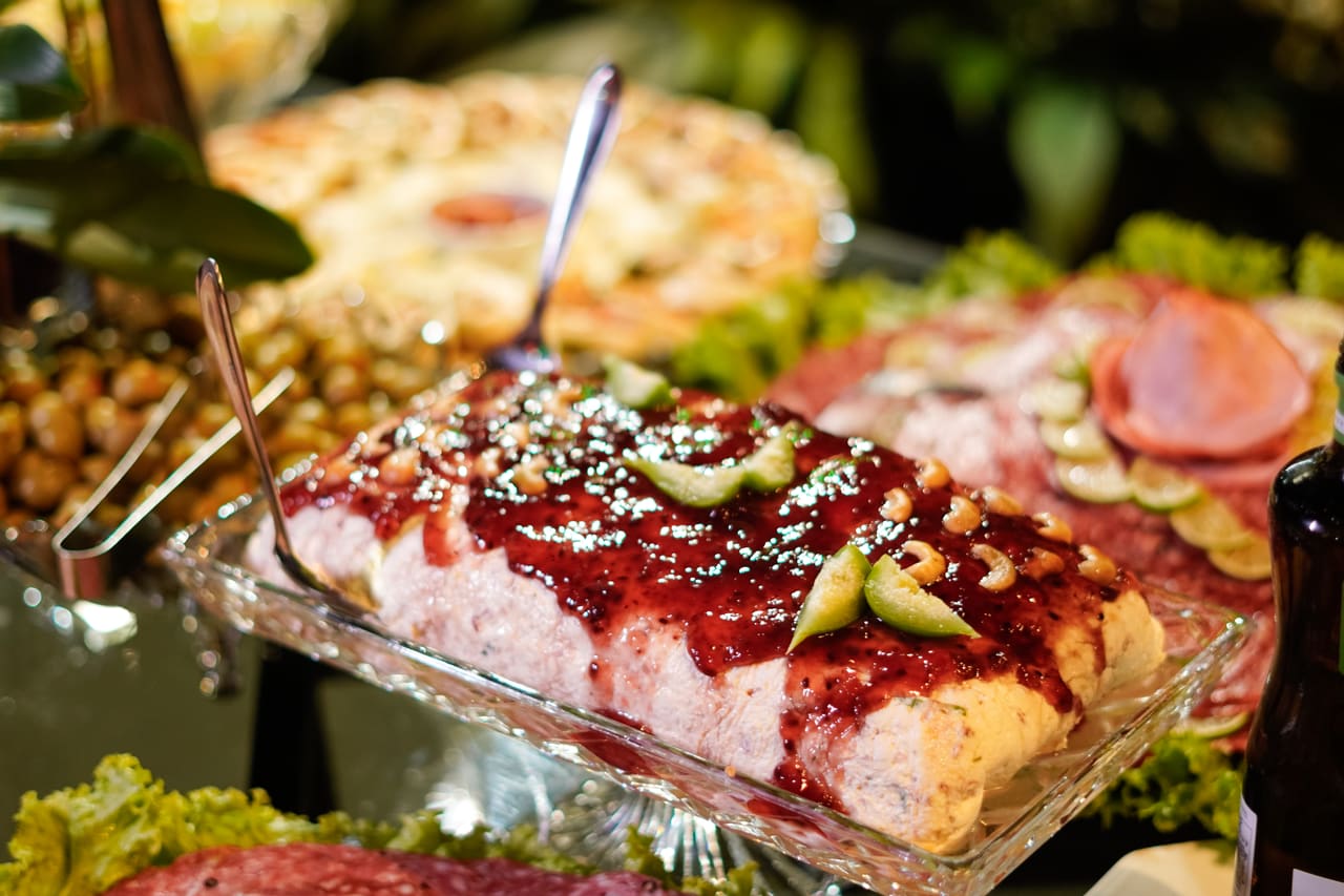 Mesa de buffet com frios, saladas e pratos variados servidos no evento